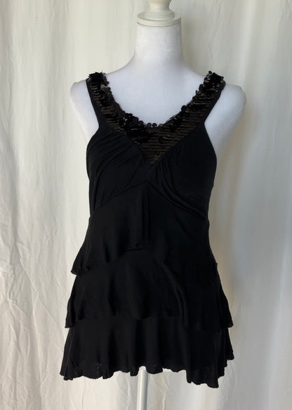 Black ruffled top on a mannequin against a white background