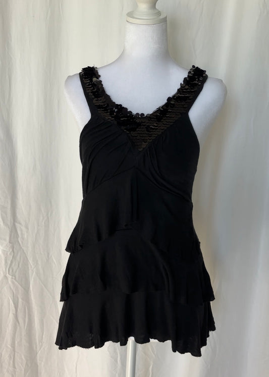 Black ruffled top on a mannequin against a white background