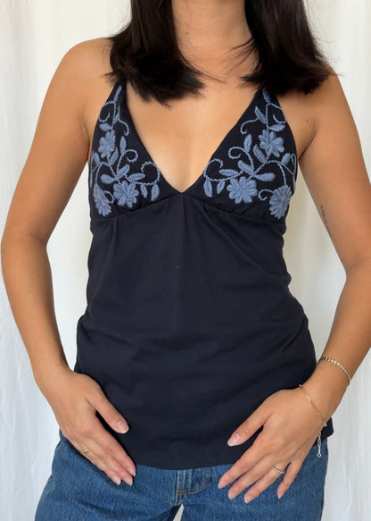 Navy tank top with blue floral embroidery worn by a person against a white background